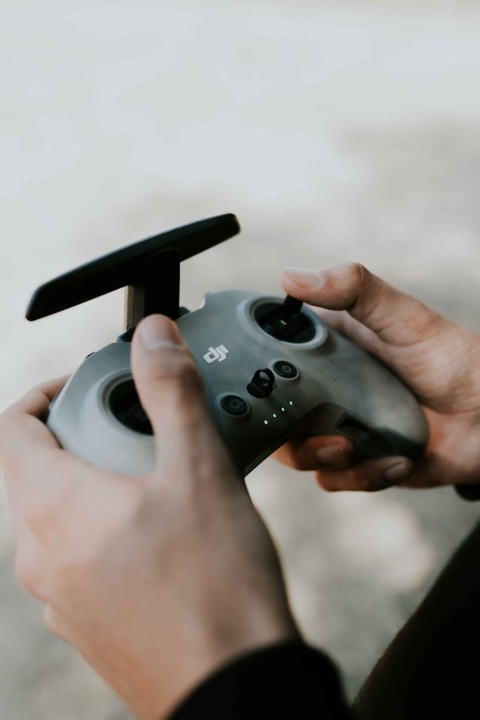 Hands holding a drone controller, focusing on the technology and user interaction.