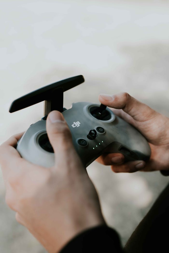 Hands holding a drone controller, focusing on the technology and user interaction.
