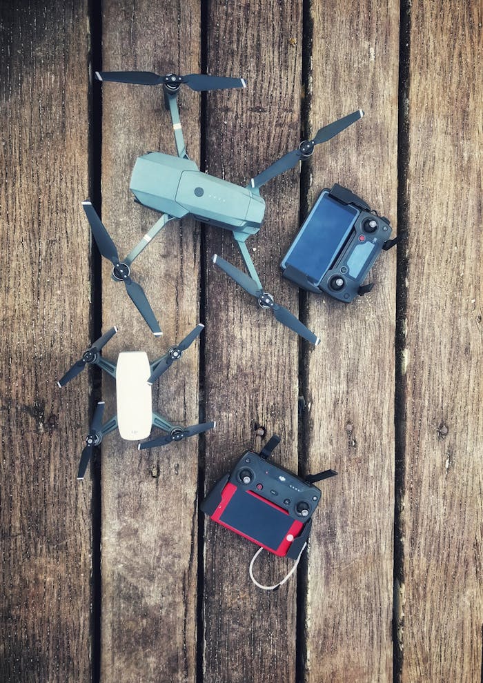 Aerial equipment and controllers displayed on a wooden backdrop, showcasing modern drone technology.